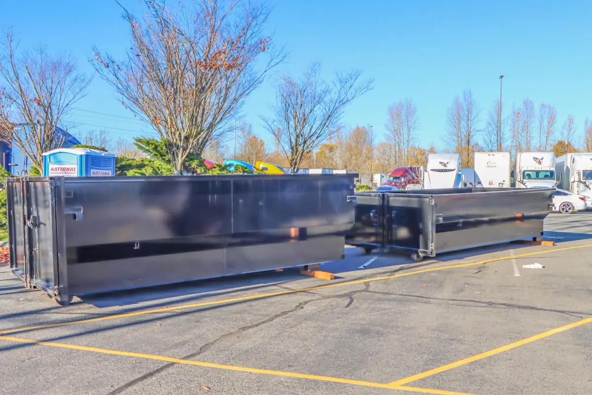 Professional dumpster rental service with roll-off container on residential driveway in Monroe